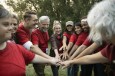 Confident volunteers joining hands in park